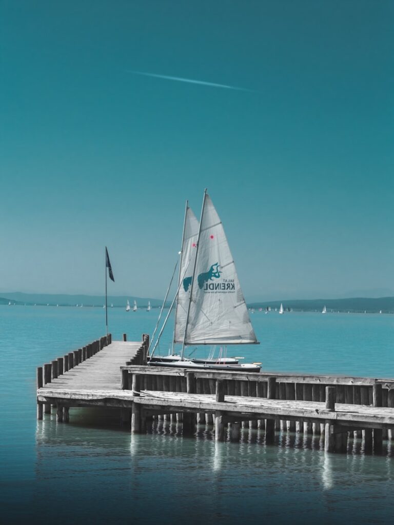 two boats beside gray wooden dock during daytime